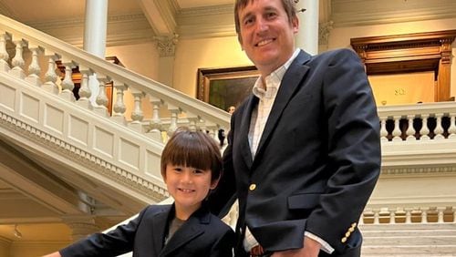 Democrat Russell Edwards and son Teddy, 8, after he qualified to run for Public Service Commission on March 11. Edwards said Tuesday that we was suspending his campaign for the District 2 seat currently held by Tim Echols, a Republican.