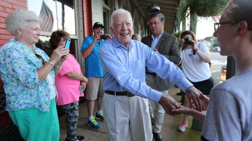 Former President Jimmy Carter received an outpouring of love on social media Saturday, Feb. 18, 2023, after news broke that he was in hospice care. Carter is shown shaking hands as he arrives at a birthday party for his wife, Rosalynn, in 2015 in Plains. (Ben Gray / AJC file photo)