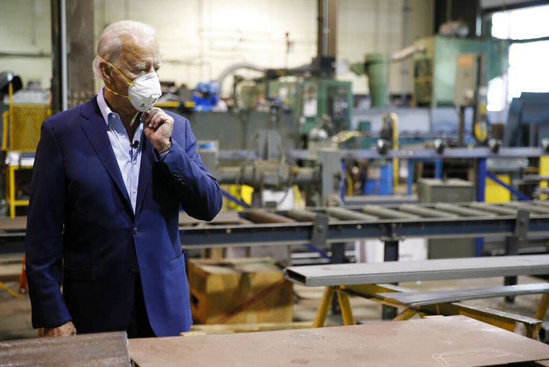 FILE - In this July 9, 2020, file photo Democratic presidential candidate, former Vice President Joe Biden adjusts his mask during a tour of McGregor Industries, a metal fabricating facility in Dunmore, Pa. Biden is pledging to define his presidency by a sweeping economic agenda beyond anything Americans have seen since the Great Depression and the industrial mobilization for World War II. (AP Photo/Matt Slocum, File)