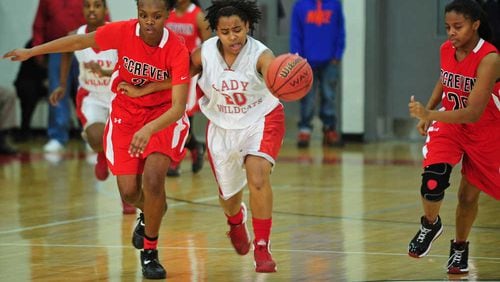 Two Screven County defenders chase after a dribbling Laney Lady Wildcats player in their game during the 2013 season. (Photo courtesy of The Augusta Chronicle)