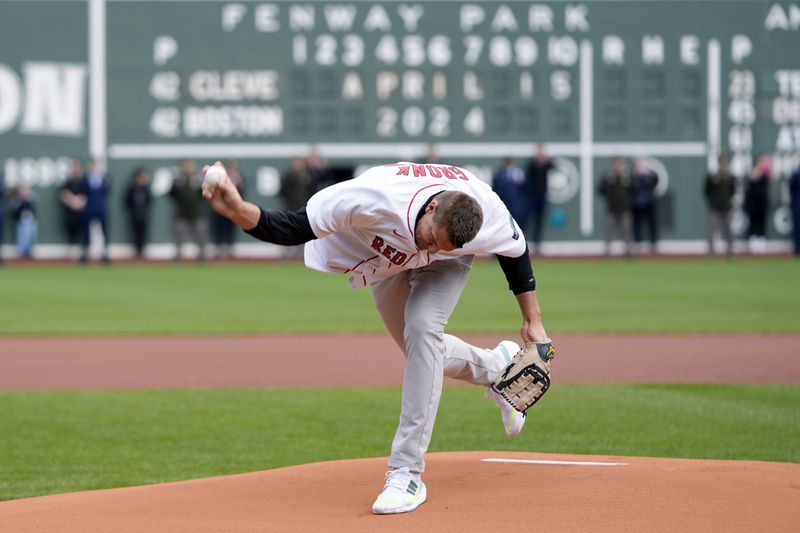 Former New England Patriots NFL football player Rob Gronkowski spikes the ball instead of throwing it during the ceremonial first pitch before a baseball game between the Boston Red Sox and the Cleveland Guardians, Monday, April 15, 2024, in Boston. (AP Photo/Michael Dwyer)