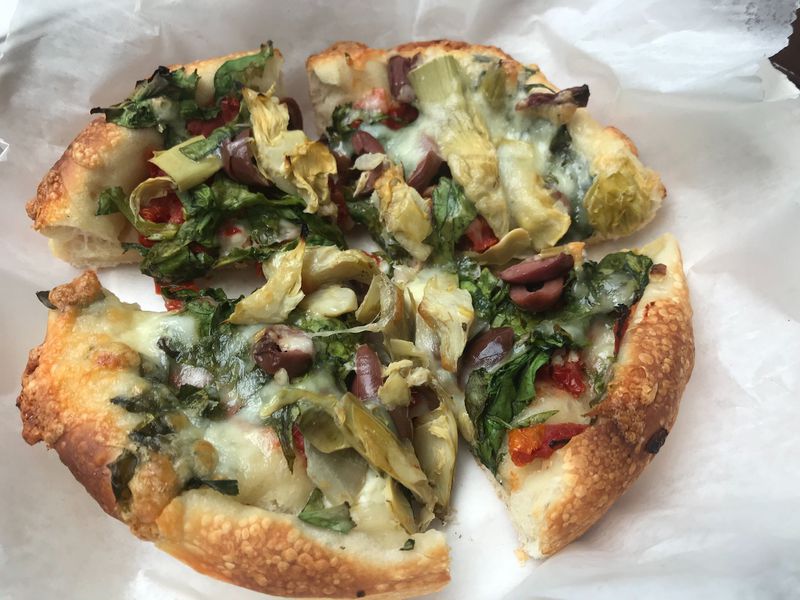 At Athens Pizza, the Santorini Special stands out for briny Kalamata olives and tart-sweet sun-dried tomatoes. LIGAYA FIGUERAS / LIGAYA.FIGUERAS@AJC.COM