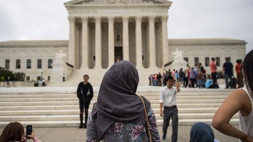 A woman wearing a hijab stands outside the U.S. Supreme Court, October 11, 2017 in Washington, DC. On Tuesday, the U.S. Supreme Court dismissed one of two cases challenging the Trump administration's effort to restrict travel from mostly Muslim countries. (Photo by Drew Angerer/Getty Images)