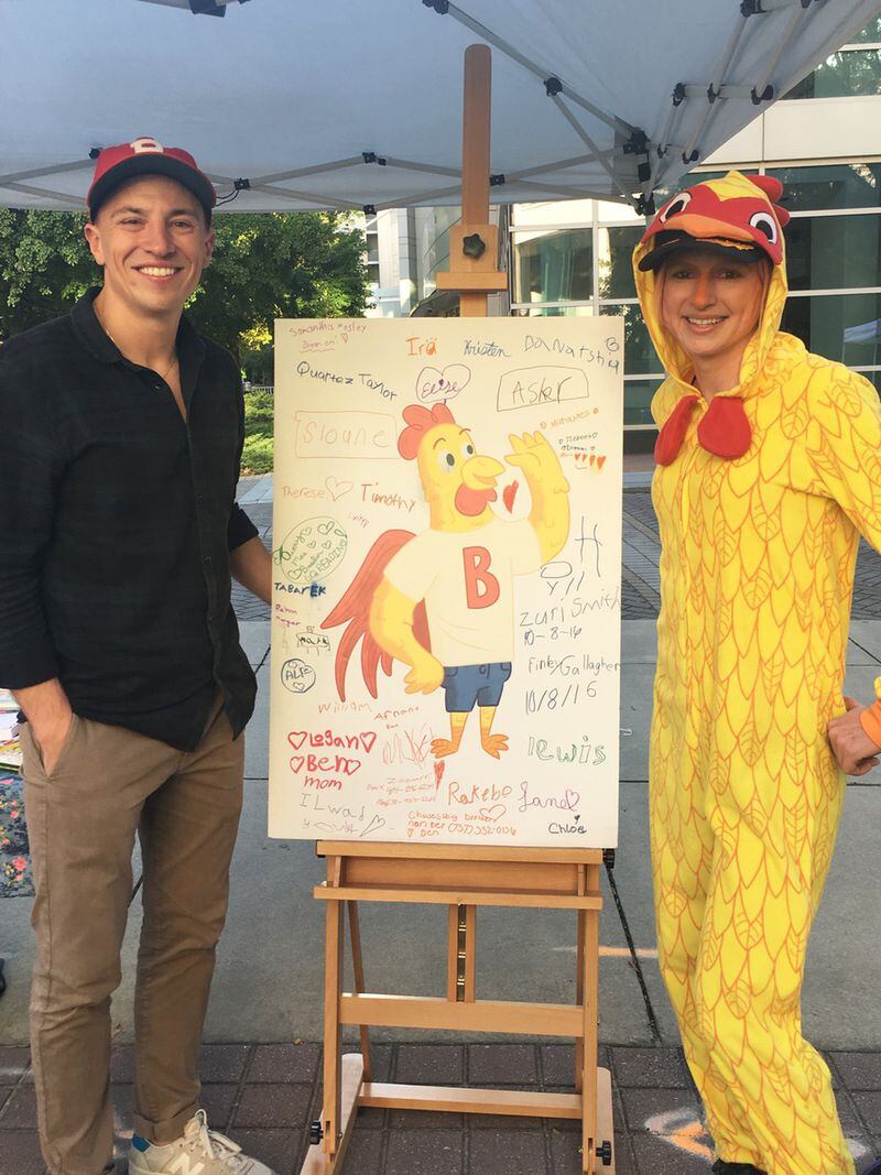 Jason Sosnovsky, the man behind Ben the Rooster, and a new friend pose with a poster of Ben at Atlanta Streets Alive in October 2016. CONTRIBUTED