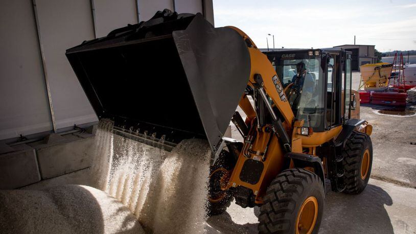 Roderick Browning pours salt into a salt barn at GDOT’s maintenance activities center where workers are preparing for possible snow this weekend, Thursday in Forest Park.