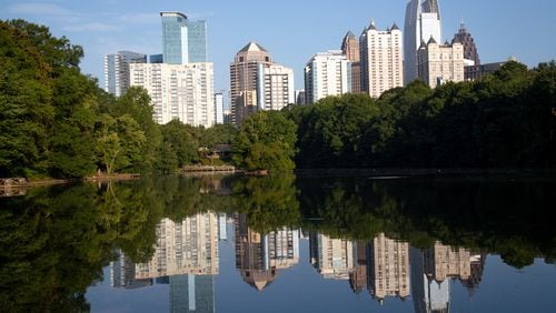 The city's skyline is reflected in the water on a quiet Friday morning at Piedmont Park July 17, 2020.  STEVE SCHAEFER FOR THE ATLANTA JOURNAL-CONSTITUTION