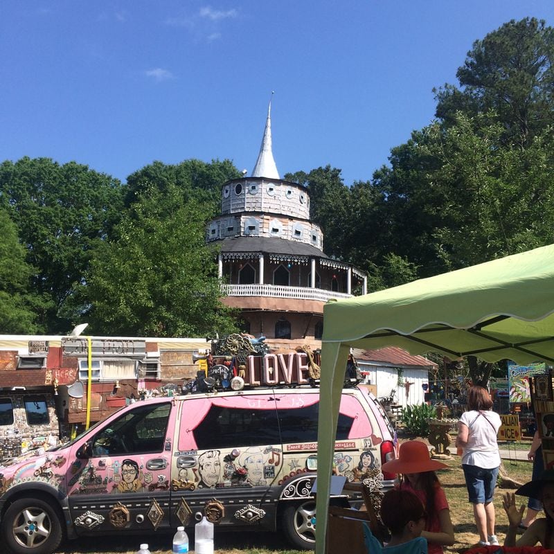  CAPTION: The "Love Machine" art car of Kentucky self-taught artists C.M. Laster and Grace Kelly Laster was a focal point at last year's Finster Fest in Paradise Garden in Summerville. Wearing an orange hat in the foreground is their daughter Ruby Laster, then 11, creating a portrait of a festival-goer. All three Lasters will return for this year's edition of Finster Fest, May 27-28. SUZY SUE SMITH / Special