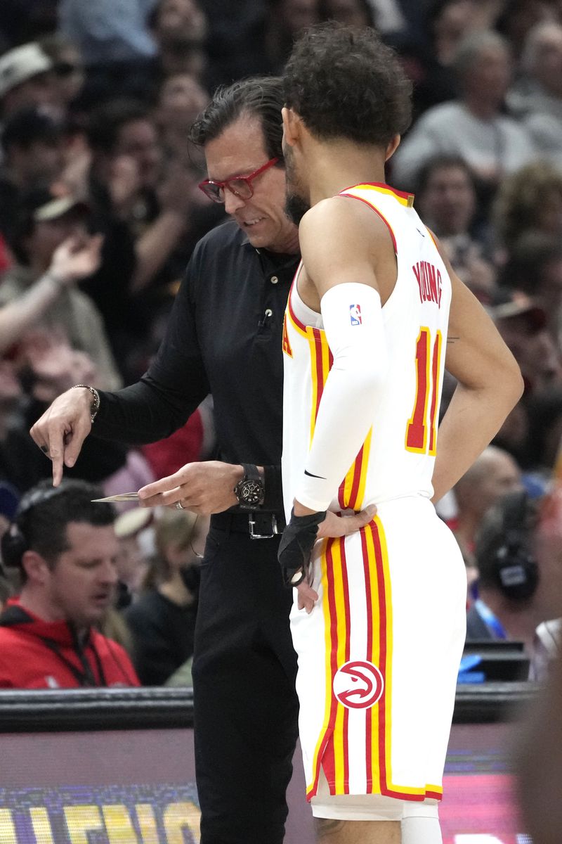 Atlanta Hawks coach Quin Snyder, left, talks to guard Trae Young during the first half of the team's NBA basketball play-in tournament game against the Chicago Bulls in Chicago, Wednesday, April 17, 2024. (AP Photo/Nam Y. Huh)