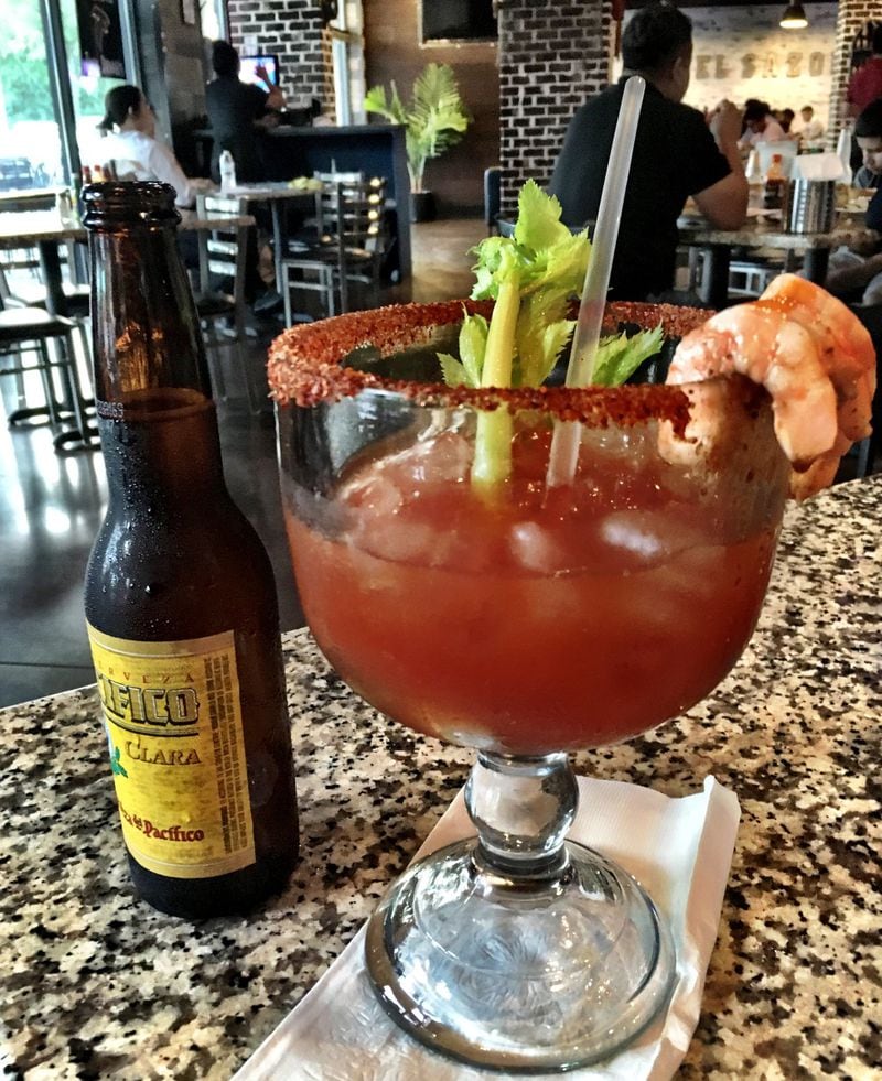 The best cocktail at Mariscos El Sazon del Kora is the house rendition of a michelada with raw oysters swimming in the drink, shrimp served on the rim, and beer served on the side. CONTRIBUTED BY WYATT WILLIAMS