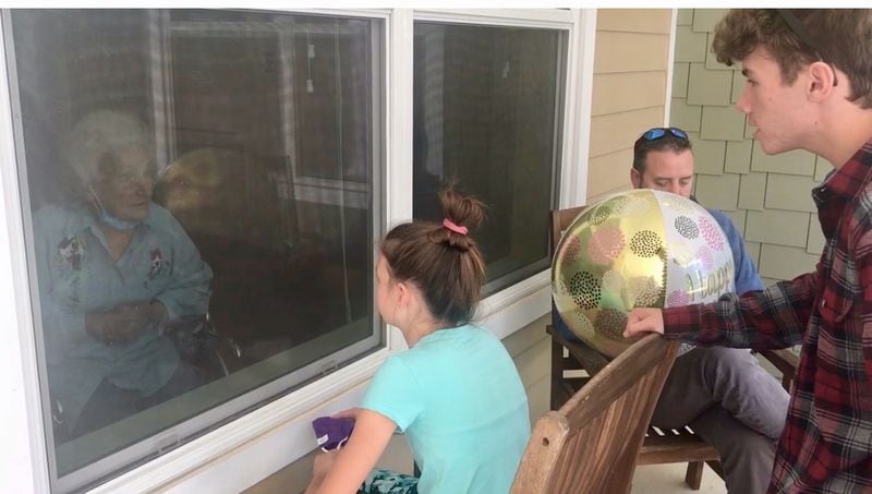 Jeanette Hicks, a resident of Orchard View nursing home in Columbus, celebrated her 93rd birthday in October through the window with her family, including her great-grandchildren. The family had to mail a birthday cake. (Photo courtesy of the family)