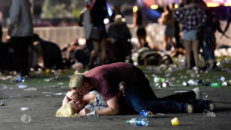 A man shields a woman with his body at the Route 91 Harvest country music festival in Las Vegas on Oct. 1, 2017, after a gunman opened fire from his nearby hotel room. At least 59 people were killed and more than 500 were injured in the deadliest mass shooting in modern U.S. history.