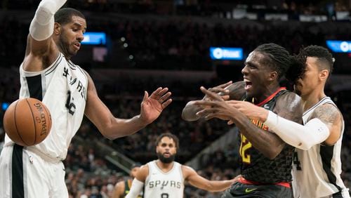 Atlanta Hawks forward Taurean Prince, center, is fouled by San Antonio Spurs' Danny Green, right, as he attempts to shoot against Spurs' LaMarcus Aldridge during the second half of an NBA basketball game, Monday, Nov. 20, 2017, in San Antonio. San Antonio won 96-85. (AP Photo/Darren Abate)