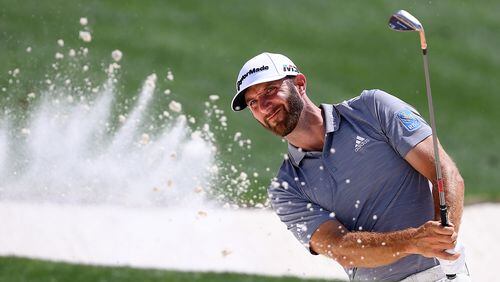 Dustin Johnson blasts from the bunker to the 18th green during his practice round for the Masters at Augusta National Golf Club on Tuesday, April 3, 2018, in Augusta.  Curtis Compton/ccompton@ajc.com