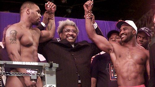 Evander Holyfield and Mike Tyson are pictured with promoter Don King on Nov. 8, 1996, at the weigh-in before their first fight at the MGM Grand in Las Vegas. The win by Holyfield cemented his place in boxing history. (AJC staff photo)