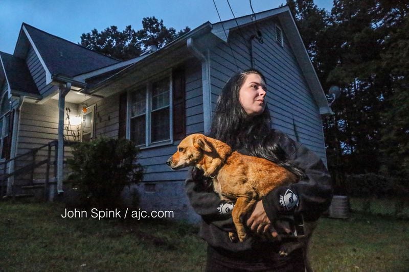 Brittney Speck holds her dog after the canine was attacked by a tiger on the loose in Henry County. 