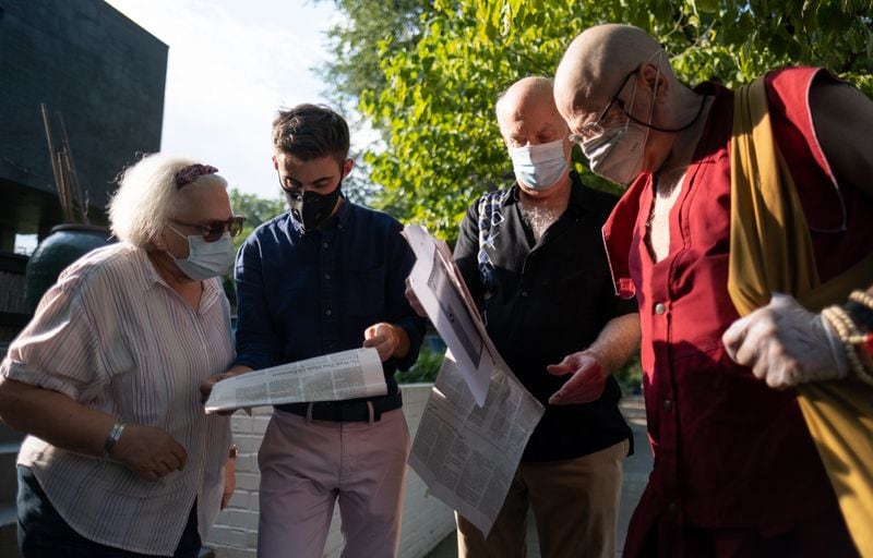 Abby Drue (from left), Charlie Paine, Dave Hayward and Gil Robison look over articles while gathered near the Virginia-Highland house where Michael Hardwick was arrested for sodomy in 1982, leading to the historic Bowers V. Hardwick case heard by the U.S. Supreme Court. Ben Gray/For the AJC