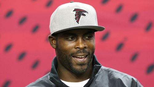 Former Atlanta Falcons quarterback Michael Vick sports a team hat as he returns to the Georgia Dome before the Falcons played the New Orleans Saints Sunday, Jan. 1, 2017, in Atlanta.