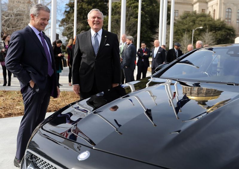 Steve Cannon, left, then the CEO of Mercedes-Benz USA, and Gov. Nathan Deal are all smiles in 2015 as they look over a Mercedes at the State Capitol following a press conference where they announced that the company’s headquarters would be relocating from New Jersey to Sandy Springs. BEN GRAY / BGRAY@AJC.COM