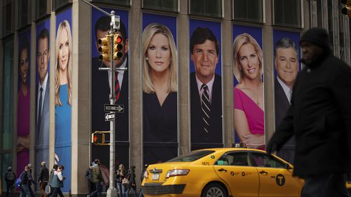 Advertisements featuring Fox News personalities, including Tucker Carlson, adorn the front of the News Corporation building, March 13, 2019, in New York.