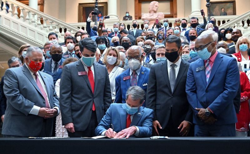 Gov. Brian Kemp signs into law House Bill 426, hate-crimes legislation, on the last day of the legislative session Friday at the Georgia Capitol. (Hyosub Shin / Hyosub.Shin@ajc.com)