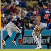 Atlanta Braves second baseman Ozzie Albies, left, can't catch a ball hit by Los Angeles Dodgers' Mookie Betts during the seventh inning Saturday night in L.A. The Braves fell 11-2.  (AP Photo/Ashley Landis)