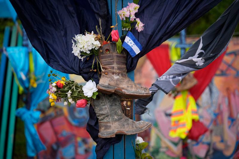 Flowers are seen at a memorial site to honor the construction workers who lost their lives in the collapse of the Francis Scott Key Bridge in Baltimore, Thursday, April 25, 2024. (AP Photo/Matt Rourke)