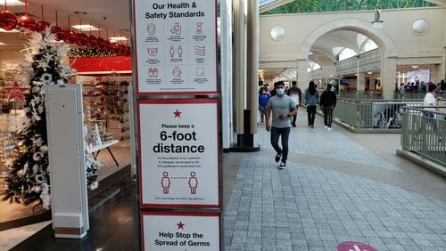 Retailers, such as Macy's at Lenox Square mall in Atlanta, are encouraging shoppers to comply with pandemic-related safety measures amid the holiday shopping season. MATT KEMPNER / AJC