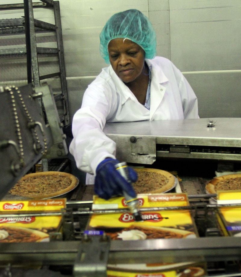 Pat Lee marks pecan pies with slight imperfections for the secondary market at the Edwards pie plant in central Atlanta.  / AJC file photo