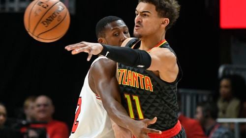 Hawks guard Trae Young (11) makes a pass as Chicago Bulls guard Kris Dunn defends during the first half of an NBA basketball game Friday, March 1, 2019, in Atlanta. (AP Photo/John Amis)