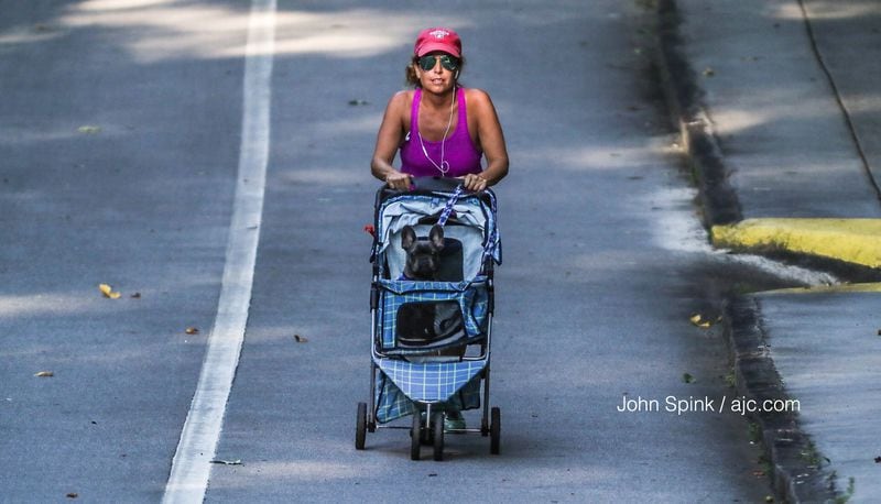 Stephanie Mendicino takes advantage of lower temperatures Tuesday morning to walk her French bulldog, Stella, 10 miles around Stone Mountain. JOHN SPINK / JSPINK@AJC.COM