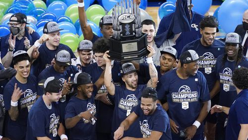 Georgia Tech guard Jose Alvarado holds the winners trophy as he and his teammates celebrate their 80-75 win over Florida State in the Championship game of the Atlantic Coast Conference tournament in Greensboro, N.C., Saturday, March 13, 2021. (AP Photo/Gerry Broome)
