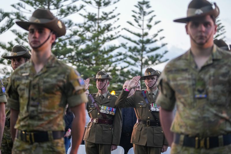 Soldiers salute during an Anzac Day dawn service at Coogee Beach in Sydney, Australia, Thursday, April 25, 2024. (AP Photo/Mark Baker)