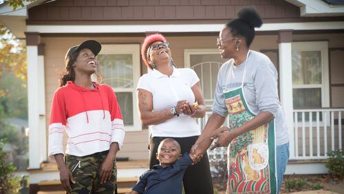 Atlanta Habitat homeowner Jamilah Najeeullah (right) shares a laugh with her daughter, granddaughter and great-grandson in front of her new home. This will be Najeeullah’s first Thanksgiving there. CONTRIBUTED