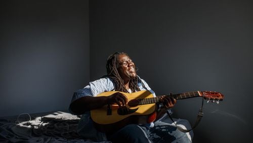 Keisha Wallace, 44, plays her guitar on her air mattress in her new home in Chicago. Wallace moved into her Woodlawn apartment recently with the help of the Flexible Housing Pool. ARMANDO L. SANCHEZ/CHICAGO TRIBUNE/TNS
