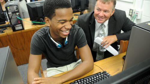 In this 2012 photo, sophomore Malik Miles (From left) shares a laugh with Fayette County Superintendent of Schools Jeff Bearden as he shows him how to do a self-assessment during the official launch of the Microsoft IT Academy at Fayette County High School in Fayetteville.