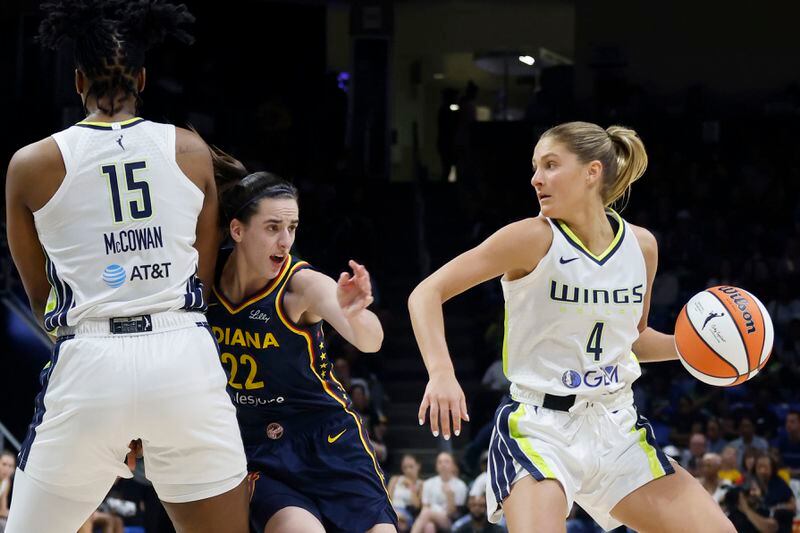 Dallas Wings guard Jacy Sheldon (4) moves the ball as Indiana Fever guard Caitlyn Clark (22) is defended by Wings center Teaira McCowan (15), during the second half of an WNBA basketball game in Arlington, Texas, Friday, May 3, 2024. (AP Photo/Michael Ainsworth)