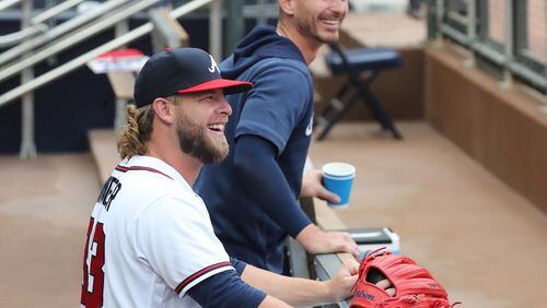 Atlanta Braves pitcher A.J. Minter is all smiles after rejoining the team in the dugout before playing the Cincinnati Reds in a MLB baseball game on Wednesday, August 11, 2021, in Atlanta.   “Curtis Compton / Curtis.Compton@ajc.com”