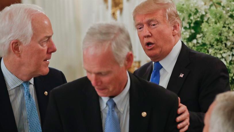 President Donald Trump stops to greet Senate Majority Whip John Cornyn of Texas, left, and Sen. Ron Johnson, R-Wis. at a luncheon with GOP leadership on Wednesday in the White House. AP/Pablo Martinez Monsivais