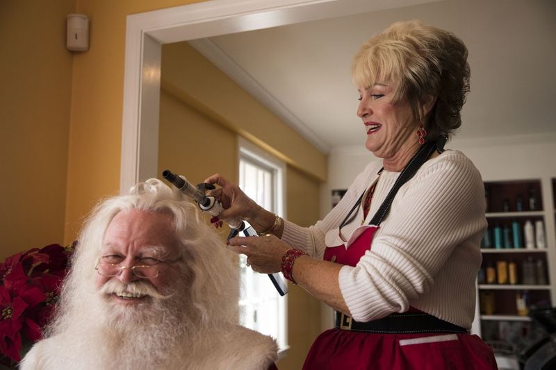 Hairstylist Sharon Franklin curls “Santa” George Price’s hair during his touch-up visit at Mela Michael’s Salon in Roswell on Dec. 12, 2017. She has styled Santas from all over the United States and even from Canada. ALYSSA POINTER / ALYSSA.POINTER@AJC.COM
