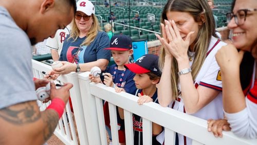 Leslie Tessler gets emotional as she sees Atlanta Braves shortstop Orlando Arcia signing an autograph to her son Lucas Torino (8) before the game against the Chicago Cubs at Truist Park on Tuesday, May 14, 2024. 

(Miguel Martinez/ AJC)