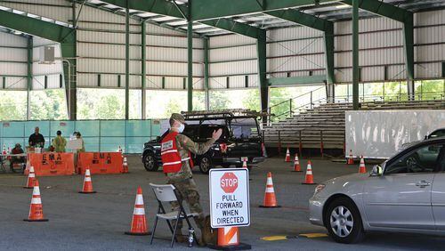 Kyle Potts, of the 170th Military Police Battalion, directs cars at the Cobb County CO-VID 19 testing site at Jim R. Miller Park in Marietta, Georgia, on Friday, April 17, 2020. The site has expanded its hours and no longer requires a doctorâs referral to be tested for the virus. (Christina Matacotta, for The Atlanta Journal-Constitution)