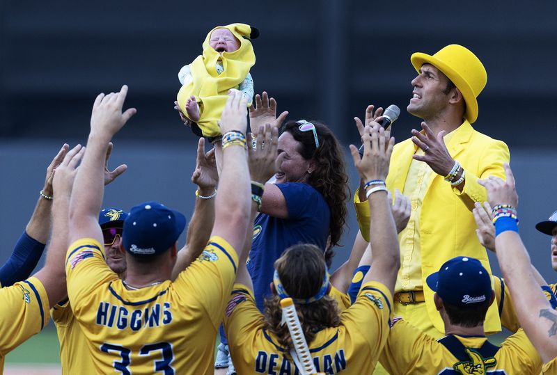 Savannah Bananas owner Jesse Cole and team members welcome a Banana Baby before a game against the Party Animals at Richmond County Bank Ball Park on Aug. 12, 2023, in New York. (Al Bello/Getty Images/TNS)