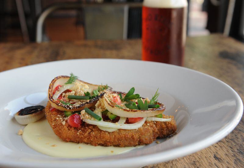 Pork loin schnitzel with “quickled” peaches and strawberries, jalapeno, charred sweet onion, peanuts, herbs and Gouda fonduta pictured with a Gate City Copperhead amber ale. (BECKY STEIN PHOTOGRAPHY)