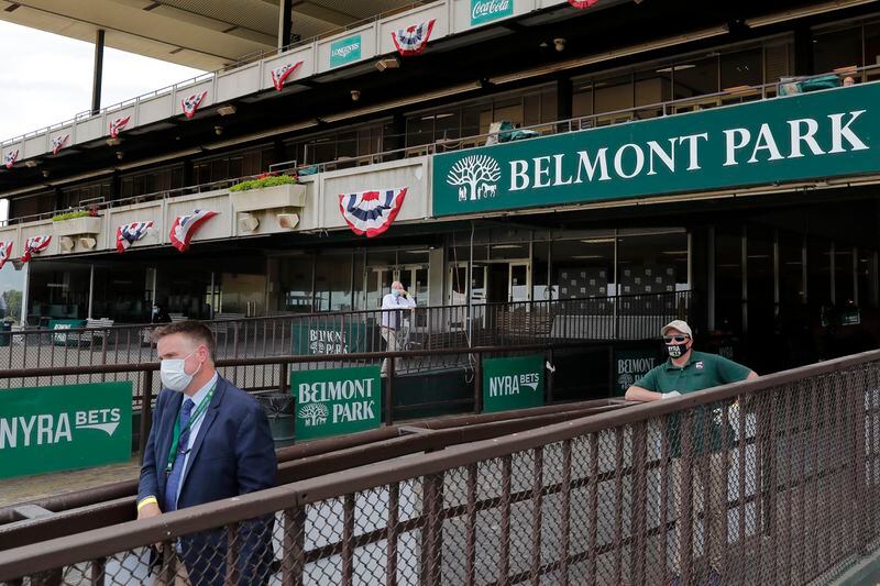 A few people watch a race at Belmont Park before the 152nd running of the Belmont Stakes horse race in Elmont, N.Y., Saturday, June 20, 2020. Tiz the Law is the star of a 10-horse field for the Belmont Stakes, perhaps the biggest event in U.S. sports since the coronavirus pandemic shut down competition in mid-March. (AP Photo/Seth Wenig)