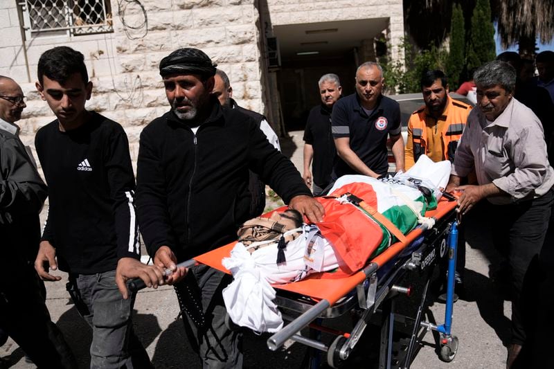 Ashraf Bani Jama' escorts the body of his son, Muhammad Bani Jama', who was shot and killed along with Abdul Rahman Bani Fadl in an Israeli settler attack earlier this week, according to Israeli Army Radio, during their funeral in the West Bank city of Nablus, Saturday, April 20, 2024. According to the Palestinian official state news agency, WAFA, the settlers were backed by the Israeli Army as they attacked the Khirbet at-Tawil area, near Nablus. Their bodies were handed over to Palestinian officials by Israel overnight. (AP Photo/Majdi Mohammed)