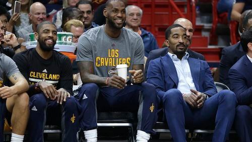 This March 4, 2017, file photo shows Cleveland Cavaliers' Kyrie Irving, left, LeBron James, center, and J.R. Smith, right, watching from the bench during the first half of an NBA basketball game against the Miami Heat, in Miami. Last season, when stars like James, Irving, Kevin Love, Stephen Curry, Klay Thompson, Draymond Green and Andre Iguodala all were given nights off when the Cavaliers or Warriors were playing nationally televised games on ABC, there was no shortage of scorn. This season, teams playing in those marquee ABC games will have a day off both before and after those contests. (AP Photo/Lynne Sladky)