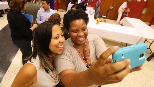 Patreece Hutcherson, right, a candidate for the Atlanta Board of Education, snaps a selfie with a supporter  during a meet and greet before an election forum in August. Hutcherson later filed a federal lawsuit against Atlanta Public Schools over a rule that would bar her from keeping her job at another metro school district should she win the election.