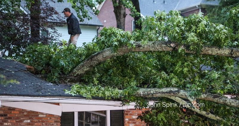 Colin Dunkley assesses damage to a customer's home in the 3600 block of Fortingale Road in Chamblee. JOHN SPINK / JSPINK@AJC.COM