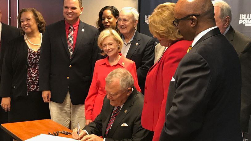 Gov. Nathan Deal signs the fiscal 2018 state budget in Atlanta. JAMES SALZER/JSALZER.AJC.COM