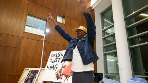 Artist Dakoro Edwards reacts after creating a live painting depicting Dexter King at Sandy Springs City Hall. The reception kicks off the City of Sandy Springs’ tribute to Black History Month. (Jason Getz / jason.getz@ajc.com)